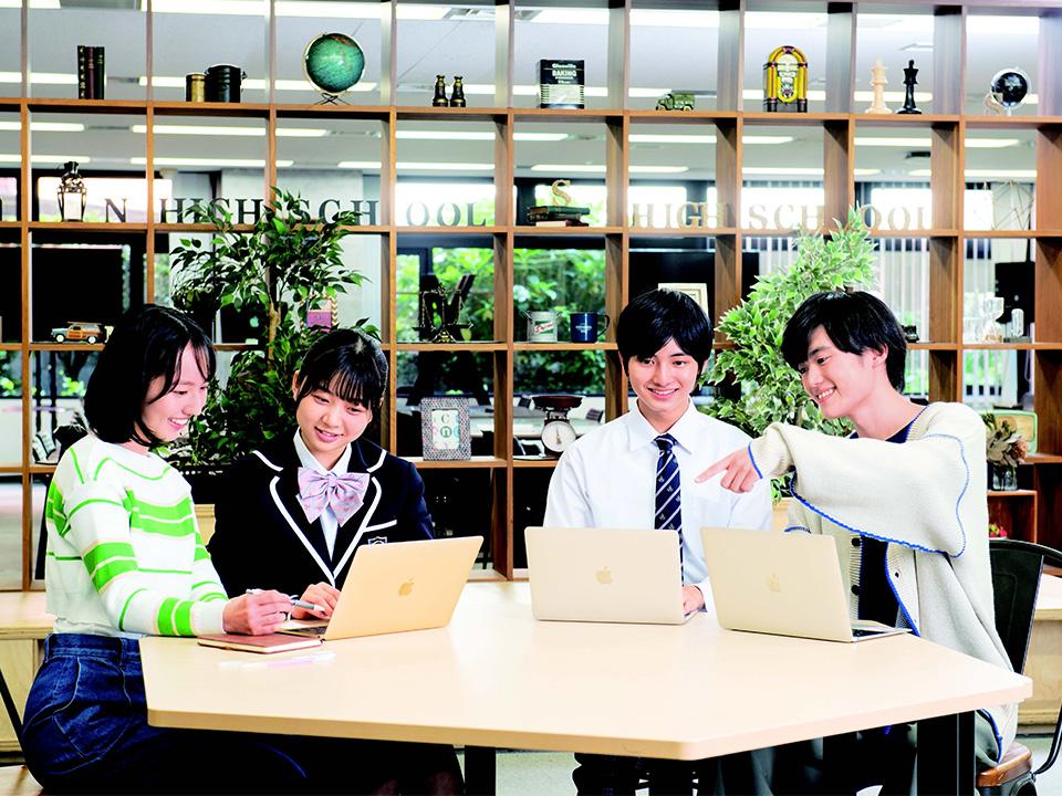 Four students are studying on laptops