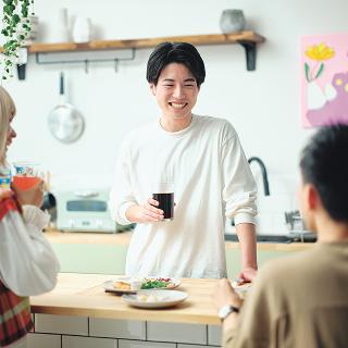 グラフを表示するパソコンの画面を見ながらディスカッションをする2人